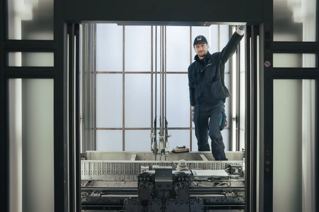 Aufzugstechniker auf der Kabine im Aufzugsschacht