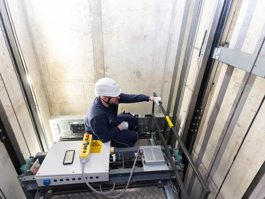 Servicetechniker auf Aufzugskabine im Schacht